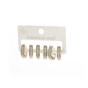 Detailed view of three pairs of silver stainless steel hoop earrings with white crystals