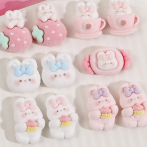 Detailed close-up of flocked cartoon bunny resin charms with strawberry and bow designs