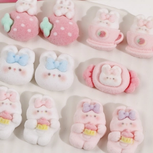 Detailed view of pink flocked bunny resin charms with strawberry and bow designs