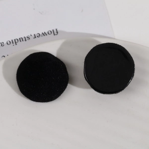 Close-up of black resin and flocked velvet circular DIY accessories on ceramic tray