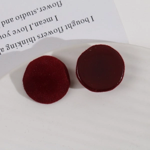 Plush faceted deep red resin cabochons on a white ceramic tray for DIY jewelry making
