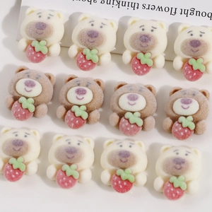 Close-up of DIY flocked bear accessories in white and brown holding red strawberries