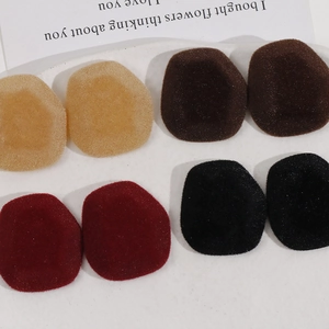Flat lay of flocked oval resin accessories in khaki, brown, burgundy, and black colors