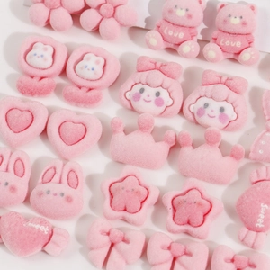 Close-up of pink flocked DIY charms including bears, flowers, and bows for hair accessories