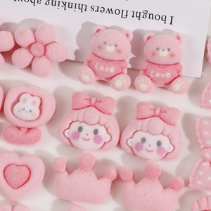 Detail of pink flocked bear, rabbit, and heart DIY accessories with soft velvet texture
