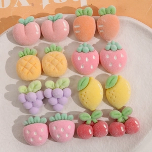 Flat lay of flocked mini fruit and vegetable charms in a ceramic plate for DIY hair clips