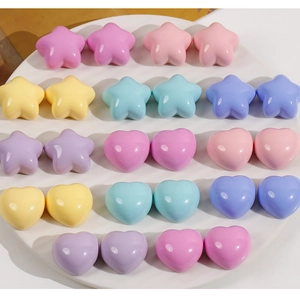 Close-up of colorful resin star and heart shapes in pastel tones on white tray