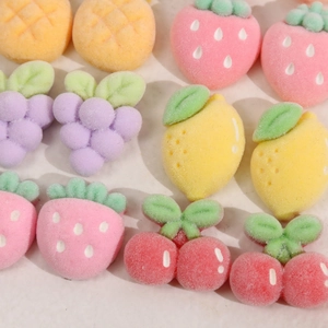 Detailed macro view of assorted flocked fruit resin charms with soft macaron velvet texture