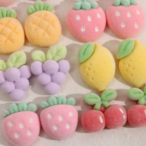 Macro detail of flocked resin fruit accessories like strawberries and grapes for DIY crafts