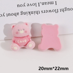 Detail showing the front and back of a pink flocked bear DIY accessory with Love text