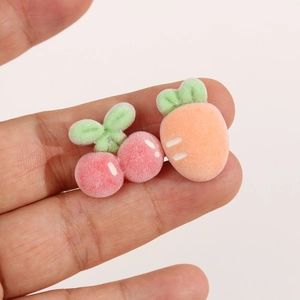Close-up of small flocked cherry and carrot charms for DIY hair accessories