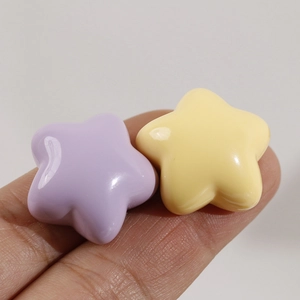 Close-up of star shaped resin charms in purple and yellow colors for DIY hair accessories