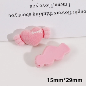 Macro shot of 15mm by 29mm pink flocked candy heart DIY hair accessory with Sweet text