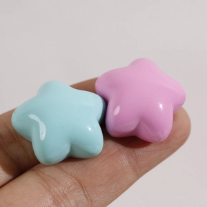 Close-up of pink and blue glossy resin star charms for DIY hair accessories making