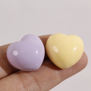 Macro view of glossy heart resin charms in lavender and pale yellow for DIY jewelry