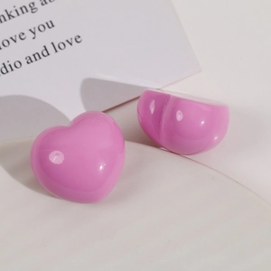 Close-up of glossy pink heart-shaped resin charms for DIY hair accessories and jewelry