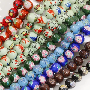 Macro shot of colorful 12mm hand-painted ceramic beads with traditional floral patterns