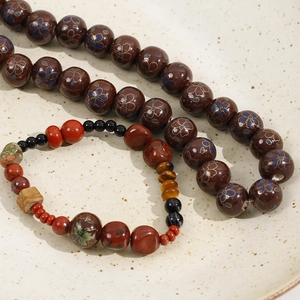 Detailed macro view of 12mm floral ceramic beads with tiger eye and red jasper stone accents