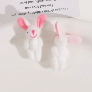 Close-up of cute plush bunny charms with pink heart stitching on a white ceramic plate