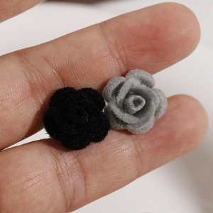 Handmade velvet rose DIY accessories in black and grey shown for size on fingertips