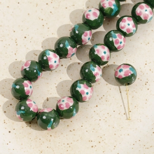 Macro detail of 12mm dark green floral ceramic beads for DIY jewelry making