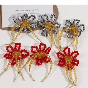 Close-up of handmade crystal beaded flower with hanging amber tassels and red faceted beads