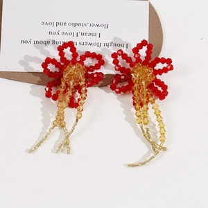 Handmade red crystal flower earrings with long beaded tassels on a decorative card