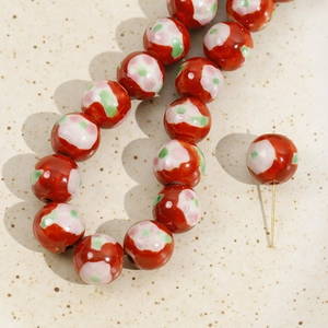 Macro shot of red 12mm floral ceramic beads with glossy glaze for DIY jewelry making