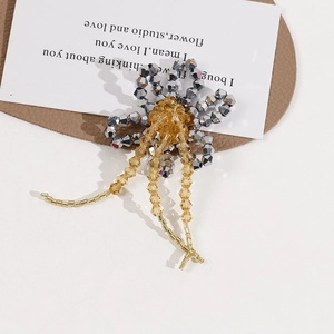 Detailed view of handmade beaded flower with yellow crystal tassels and silver petals