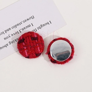 Vue macro de l'accessoire bouton en tissu tissé rouge 25mm avec base en métal argenté