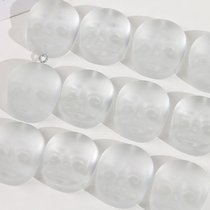 Macro view of matte translucent baby head resin charms for DIY jewelry making