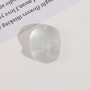 Macro view of matte translucent resin doll face pendant with hanging hole for DIY jewelry