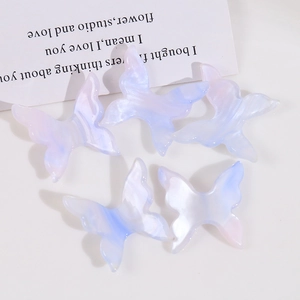 Dettaglio di cinque ciondoli a farfalla in acrilico blu e viola per creazioni fai-da-te
