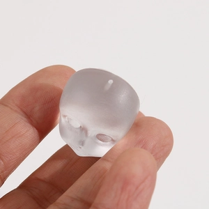 Close-up of translucent matte doll head resin pendant with hole for DIY jewelry making