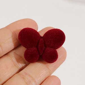 Dunkelrote beflockte Schmetterling-Haardeko in der Hand zur Größenansicht für DIY-Zubehör
