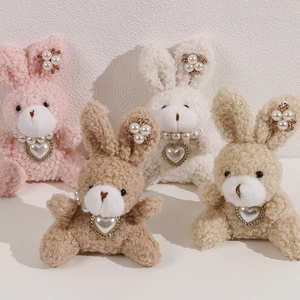 Detail of plush rabbit dolls with pearl heart necklaces in four different colors