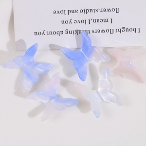 Close-up of translucent gradient resin butterfly charms for DIY jewelry and hair clips