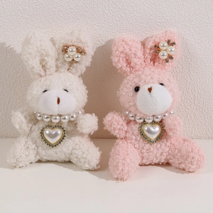 Cute plush bunny dolls with pearl necklaces in soft pink and creamy white teddy fur