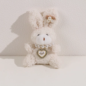 Detail of plush white rabbit with a pearl heart necklace and sparkling rhinestone pendant