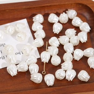 Gros plan de perles tulipes en acrylique blanc nacré pour création de bijoux DIY