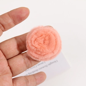 Close-up of pink faux fur rose accessory showing soft layered plush petal texture
