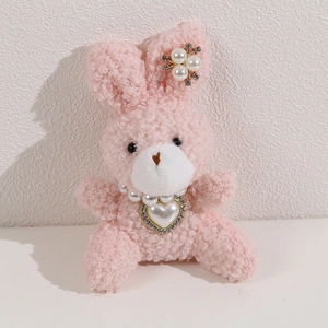 Close-up of pink plush bunny with faux pearl necklace and sparkling heart pendant