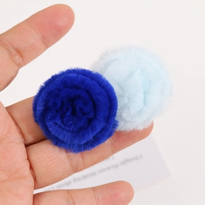 Detailed macro view of soft dark and light blue plush flower pompom hair accessories