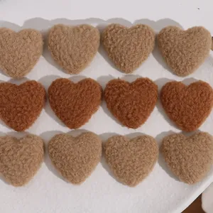 Flat lay of heart-shaped lamb wool plush DIY accessories in brown and tan tones