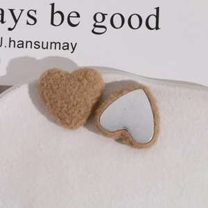 Macro view of plush heart-shaped khaki faux fur accessories with flat metal backing