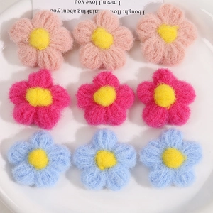 Macro shot of colorful handmade crochet flowers with yellow stamens in a white ceramic bowl