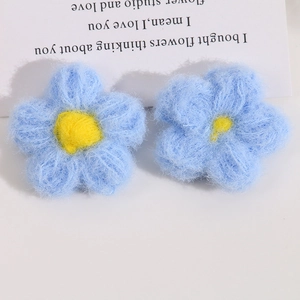 Macro detail of handmade crochet puffy five-petal flowers in sky blue and yellow