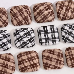 Close-up of geometric square fabric buttons featuring vintage plaid and checkered patterns