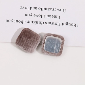 Dettaglio di bottoni in metallo floccato quadrato taupe da 18mm per accessori fai da te