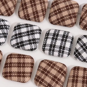 Close-up of square fabric buttons with classic black white and brown checkered patterns